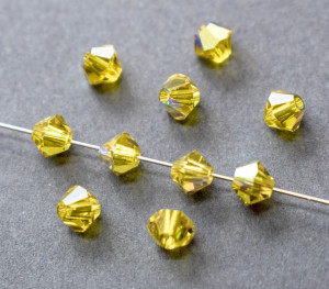 Кришталеві намистини Swarovski біконус 5328, 4мм Light Topaz AB