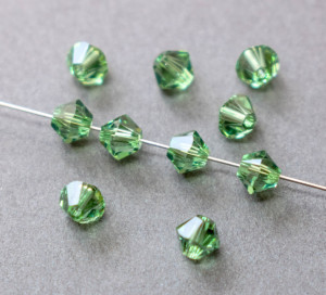 Кришталеві намистини Swarovski біконус 5328, 4мм Peridot